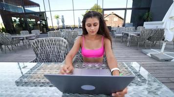mujer en bikini se sienta afuera usando una computadora portátil video