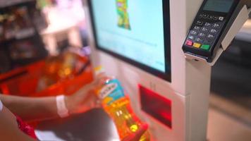 Woman uses self check out at grocery store video