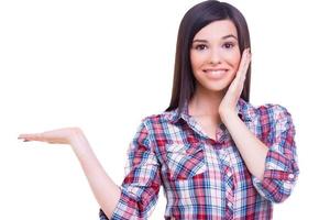 Can you believe it Surprised young woman holding copy space and touching face with hands while standing isolated on white photo