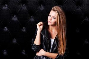 Glamour fashion model. Beautiful young woman with make up and hairstyle posing against black background photo