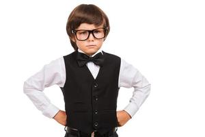 Confident and intelligence. Portrait of serious young boy in bow tie looking at camera while isolated on white photo