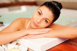 Hot tub relaxation. Attractive young woman relaxing in hot tub and looking at camera photo