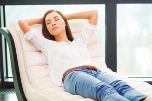 Total relaxation. Beautiful young woman holding hands behind head while sleeping on the couch photo