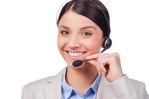 Busy at her work. Confident young customer service smiling while standing against white background photo