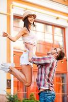 Having fun together. Happy young loving couple having fun while standing outdoors photo