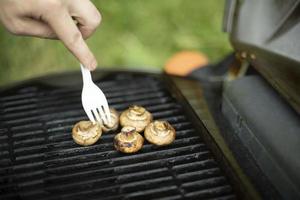 Mushrooms are grilled. Picnic details. Food on steel grate. photo