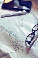 Map, map of Washington state, pen, glasses, cell phone, coffee cup on the table. photo