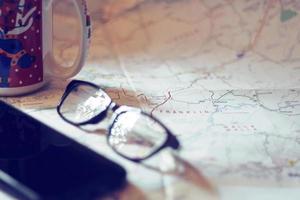 Map, map of Washington state, pen, glasses, cell phone, coffee cup on the table. photo