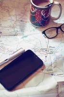 Map, map of Washington state, pen, glasses, cell phone, coffee cup on the table. photo