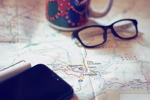 Map, map of Washington state, pen, glasses, cell phone, coffee cup on the table. photo