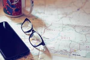 Map, map of Washington state, pen, glasses, cell phone, coffee cup on the table. photo