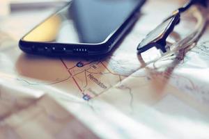 Map, map of Washington state, pen, glasses, cell phone, coffee cup on the table. photo