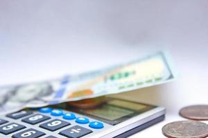 Calculator and dollar bills are placed on a white table. photo