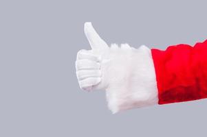 Santa Claus recommends. Close-up of Santa Claus showing his thumb up against grey background photo
