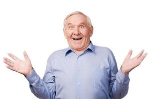 Can you believe that Excited senior man gesturing and smiling while standing against white background photo