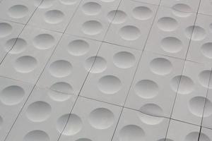 The close-up of grey detailed sphere texture reverse side of the plastic tile. Rough embossed lattice. Concept of design. Wall decoration interior. Relief balls geometric pattern. Flatlay, mock up photo
