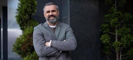 portrait of an adult successful grey-haired businessman with a smile on his face photo