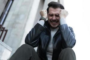 a man at the time of a panic attack sits in the city on the steps photo