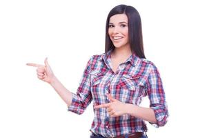 Just look at this Happy young smiling woman pointing copy space while standing isolated on white photo