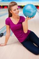 My favorite game. Beautiful young women sitting on the floor against bowling alleys photo