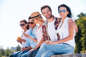 There is nothing but good friends. Group of young happy people spending time together while cheerful couple bonding to each other and looking at camera with smile photo