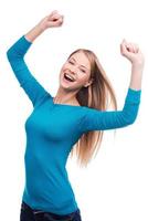 Victory is my second name Portrait of a beautiful young woman keeping her arms raised standing against white background photo