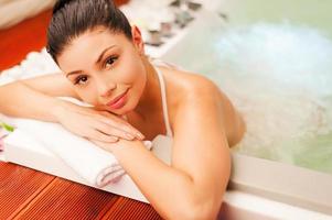 Woman in Jacuzzi. Attractive young woman relaxing in hot tub and looking at camera photo