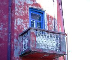 Esquina de edificio antiguo rojo con balcón con puerta de marco azul foto