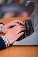 Working at the typewriter. Close-up of man typing something on typewriter photo