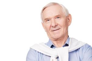 hombre mayor confiado. retrato de un anciano sonriendo a la cámara mientras se enfrenta a un fondo blanco foto