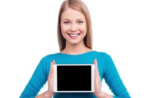 lo más útil. hermosas mujeres jóvenes sosteniendo una tableta digital y sonriendo mientras están de pie contra un fondo blanco. foto