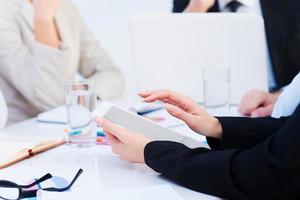 Working moments. Close-up of business people working while sitting at the table together photo