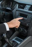 Examining his new car. Close-up of man in formalwear touching dashboard with finger while sitting in car photo