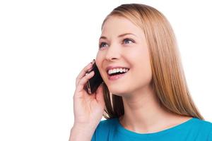 Great news Happy young women talking on the mobile phone and smiling while standing against white background photo