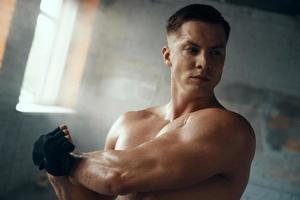 Concentrated young man warming up before training in gym photo