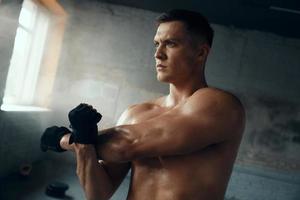 Confident young man warming up before training in gym photo