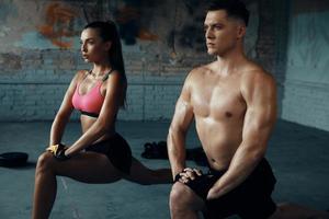 Confident fit couple doing warming up before training in gym together photo