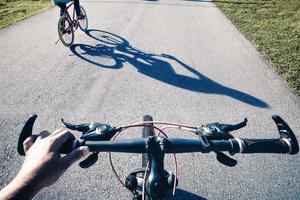 un punto de vista personal sobre una bicicleta con otro ciclista delante foto