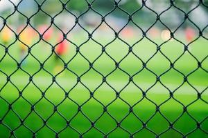 Close-up view of a soccer field perimeter fence net photo