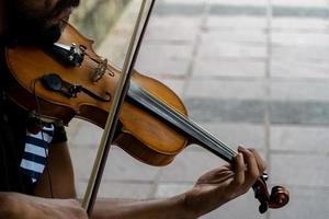 hombre tocando el violín. tema musical los dedos masculinos agarran las cuerdas y sostienen el arco foto