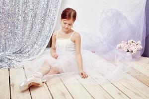 Girl in a white ball gown and shoes, beautiful red hair. Young theater actress photo