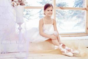 la joven bailarina se está preparando para una actuación de ballet. pequeño ballet prima foto