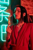 Anime woman in a red suit with short hair cut, black hair. A killer girl in a red jacket with a dagger in her hand. Beauty portrait photo