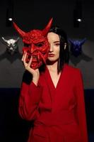 Anime woman in a red suit with short hair cut, black hair. A killer girl in a red jacket with a red Japan mask. Beauty portrait photo