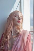 retrato de belleza de una princesa elfa de anime con cabello rosado en ropa interior. fabulosa mirada mágica, hermoso maquillaje rosa. borde corona en la cabeza de una mujer foto