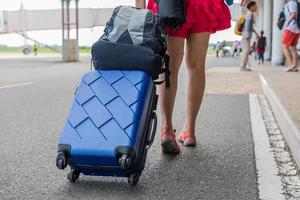 mujer lleva equipaje, maleta en la terminal del aeropuerto, turismo, bolsa turística. foto