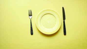 Yellow plate on yellow background hands reach out to pick up silverware video
