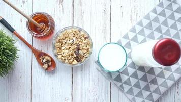 Obenliegende Pfanne der Frühstückstischplatte mit Müslimilchlöffel und Honig video