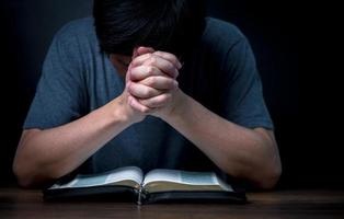 Man folding hands, Praying hands with faith in religion and belief in God on dark background, Power of hope or love and devotion. photo