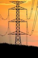 Silhouettes of high voltage poles and power lines It has a complex steel structure, it is strong and durable. photo